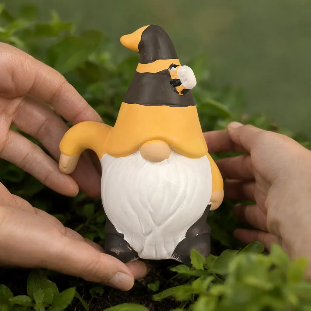Hands placing a small ceramic garden gnome with a bee hat among green plants