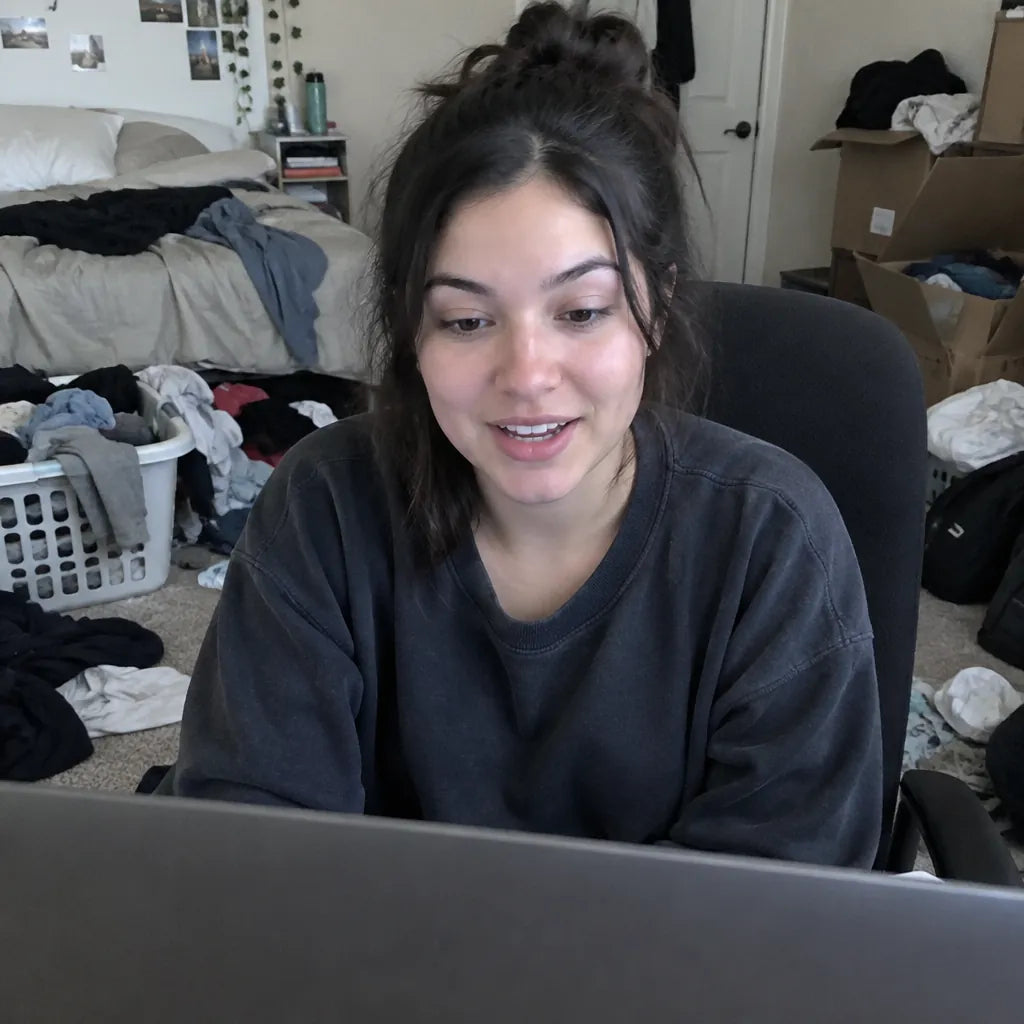Person on a video call with a cluttered bedroom behind them