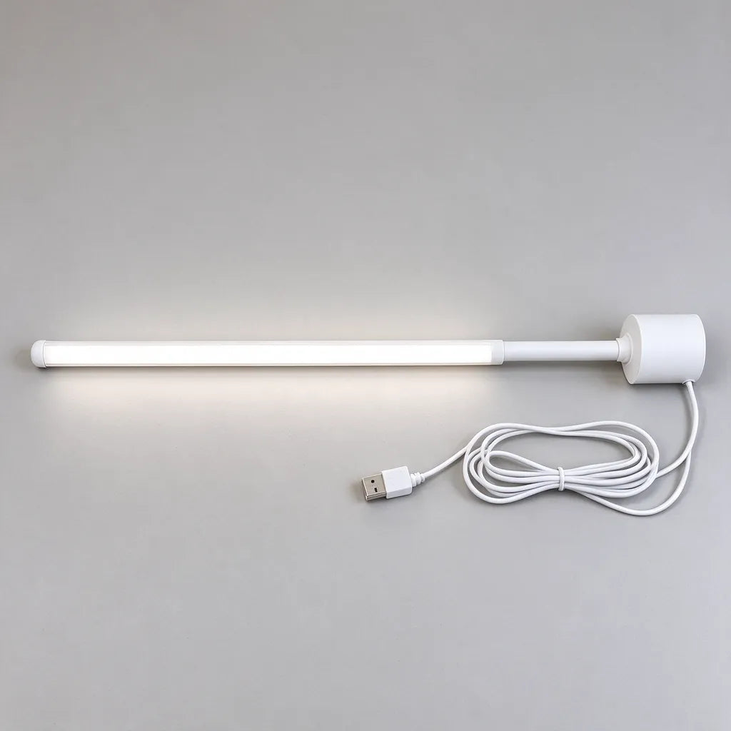 Slim white LED floor lamp laid flat with its round base and USB cord