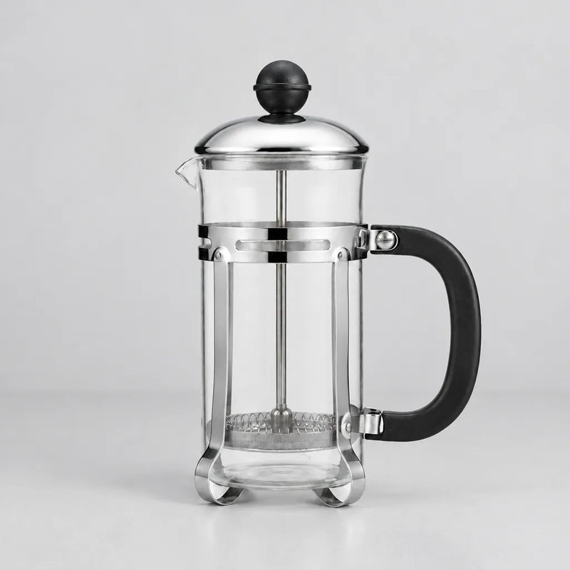 One glass French press with lid and plunger on a light grey surface