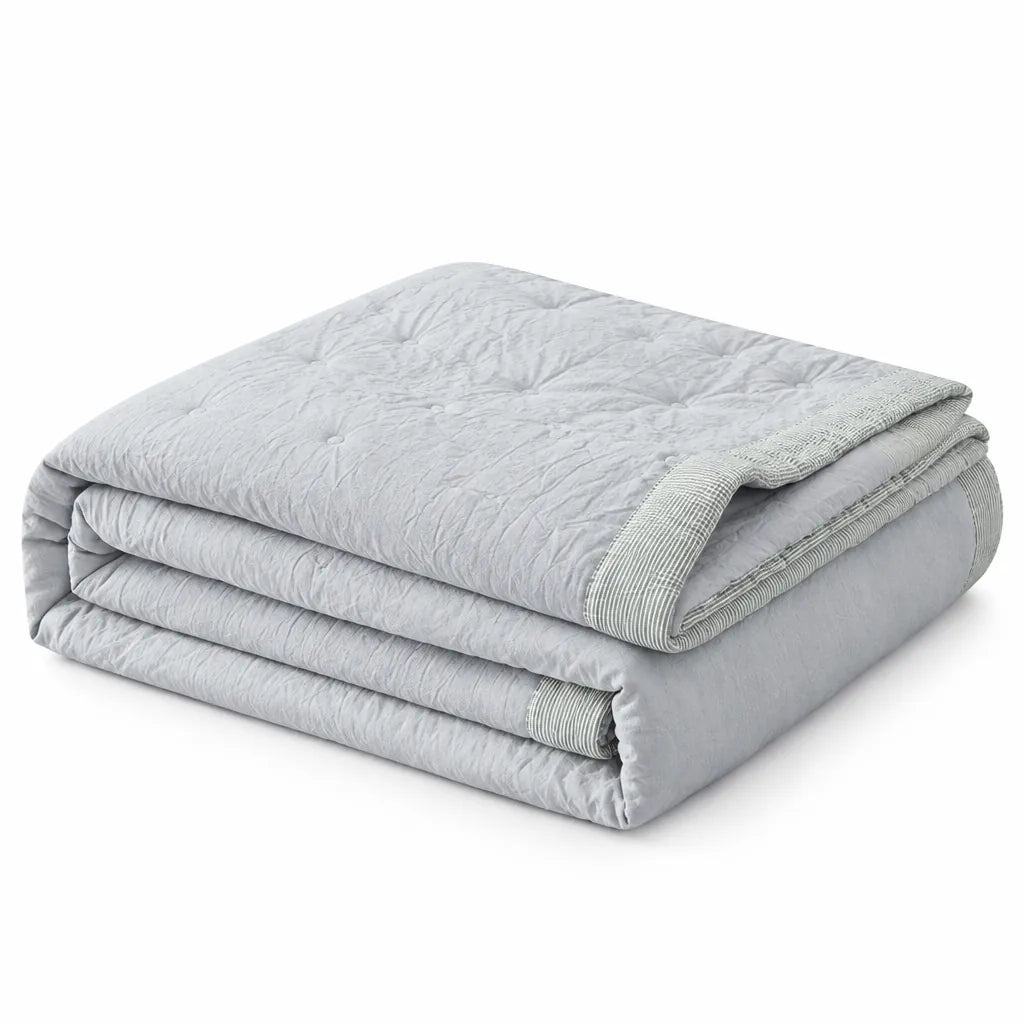 Folded light grey lightweight cotton summer duvet on a white background
