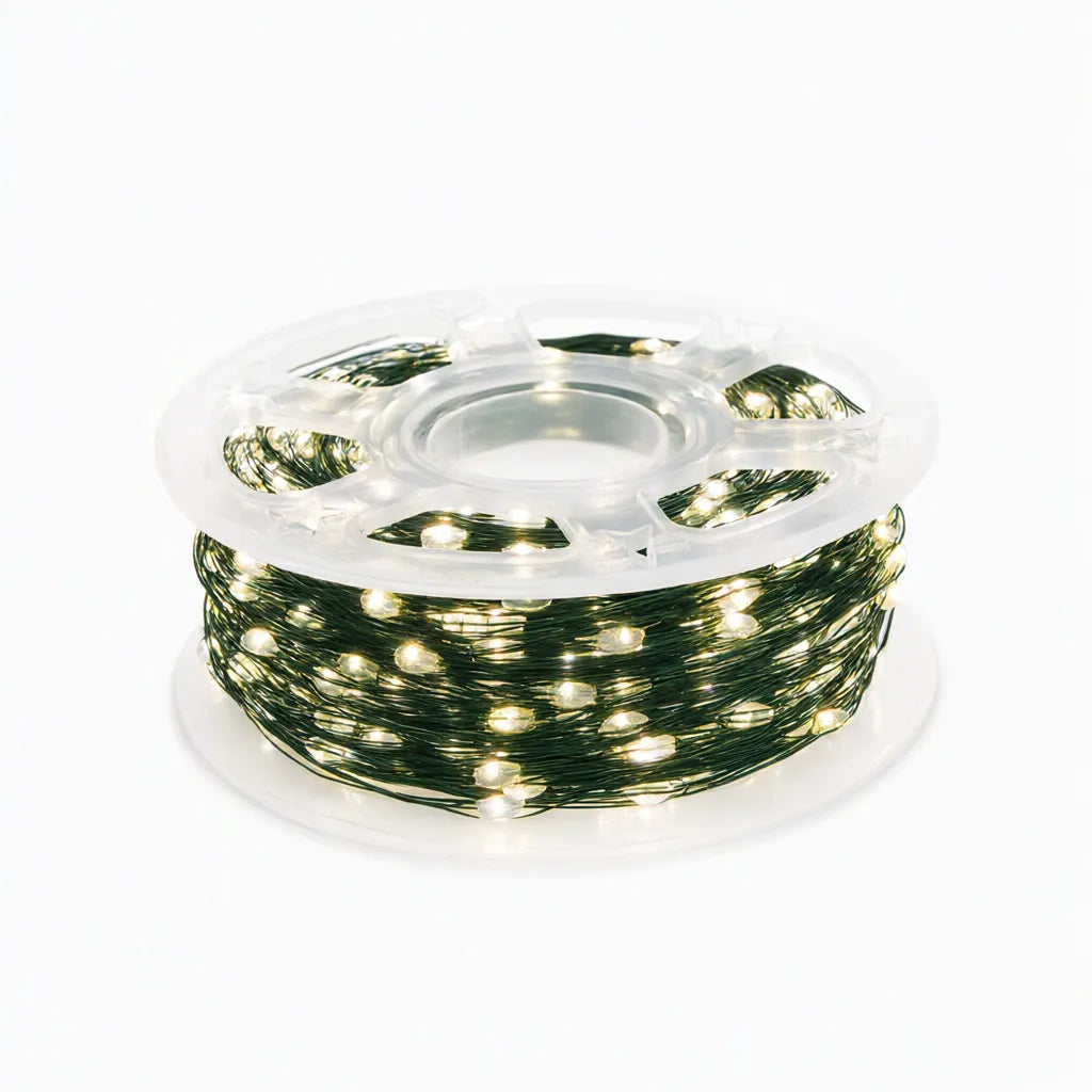 Reel of green wire warm white LED Christmas tree lights on white background