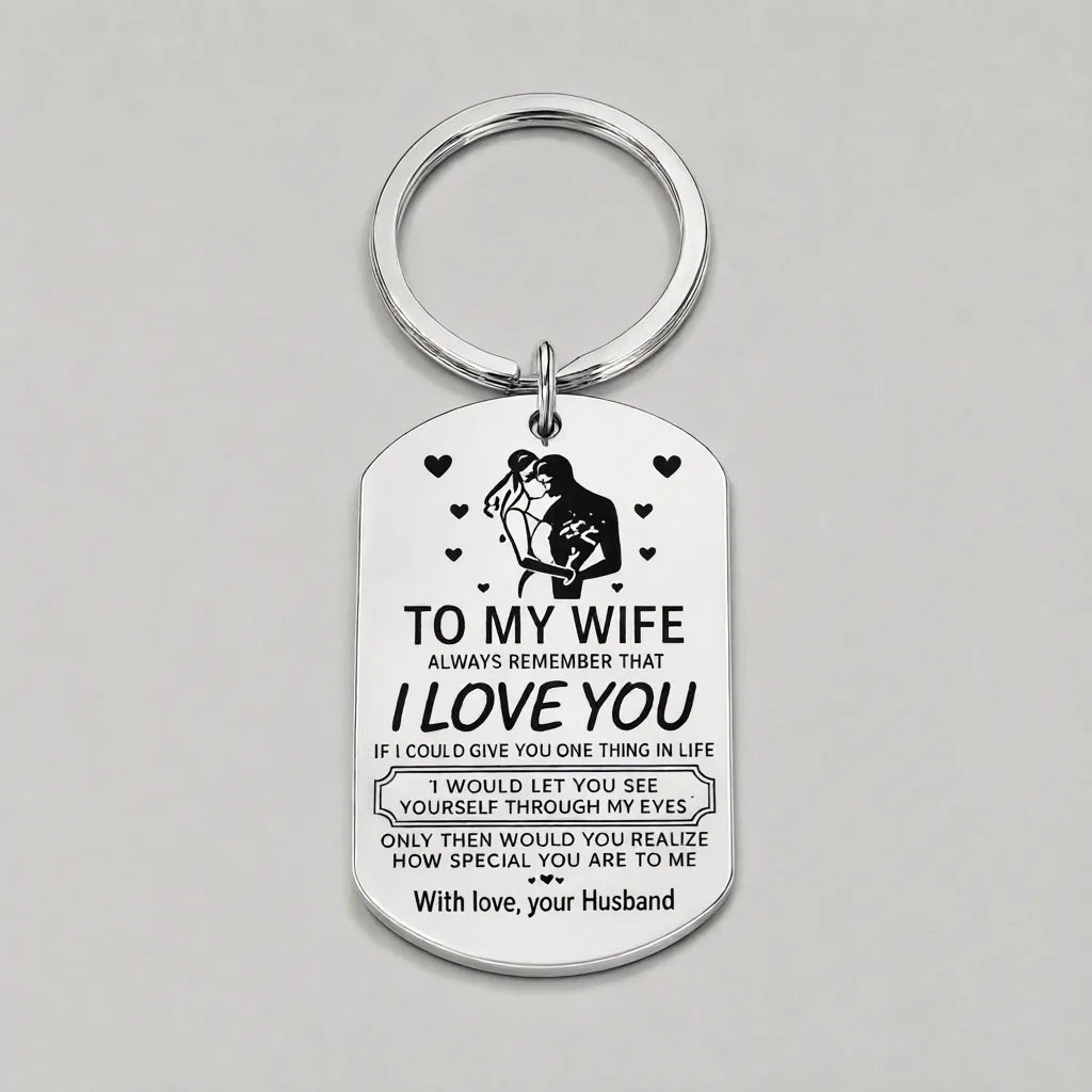 Single silver engraved steel keychain with split ring on a grey surface