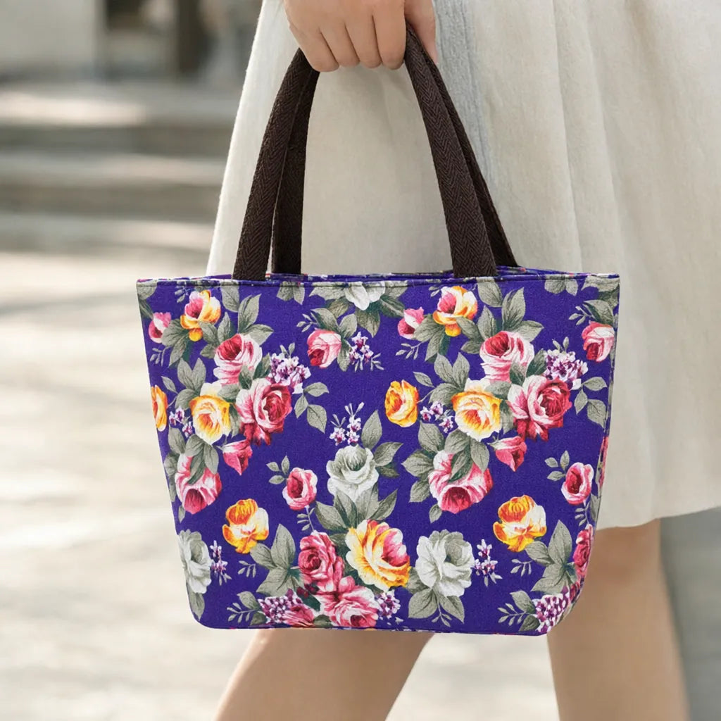 Hand carrying a small purple floral canvas tote bag