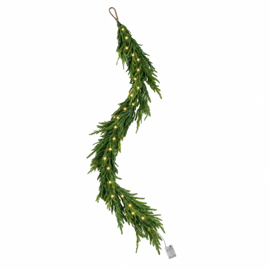 Artificial Norfolk pine Christmas garland with warm white LED lights on white background