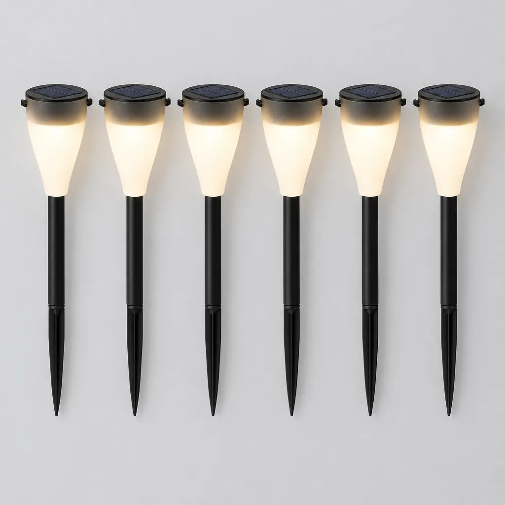 Six solar pathway lights laid side by side on a grey surface
