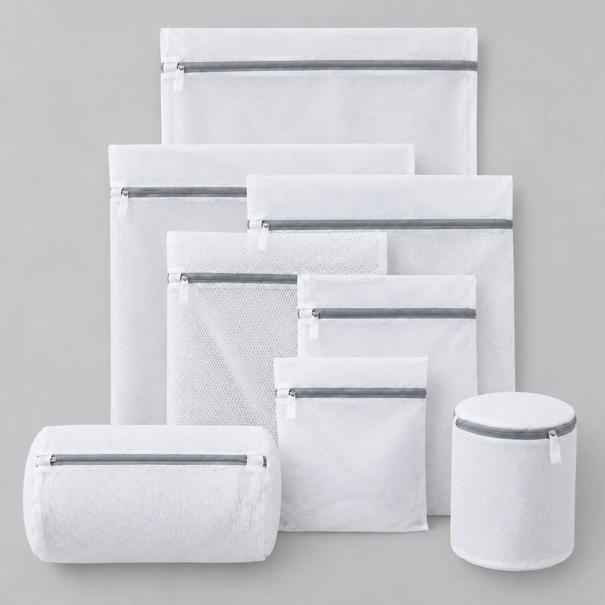 Set of white mesh wash bags laid flat on a light grey surface