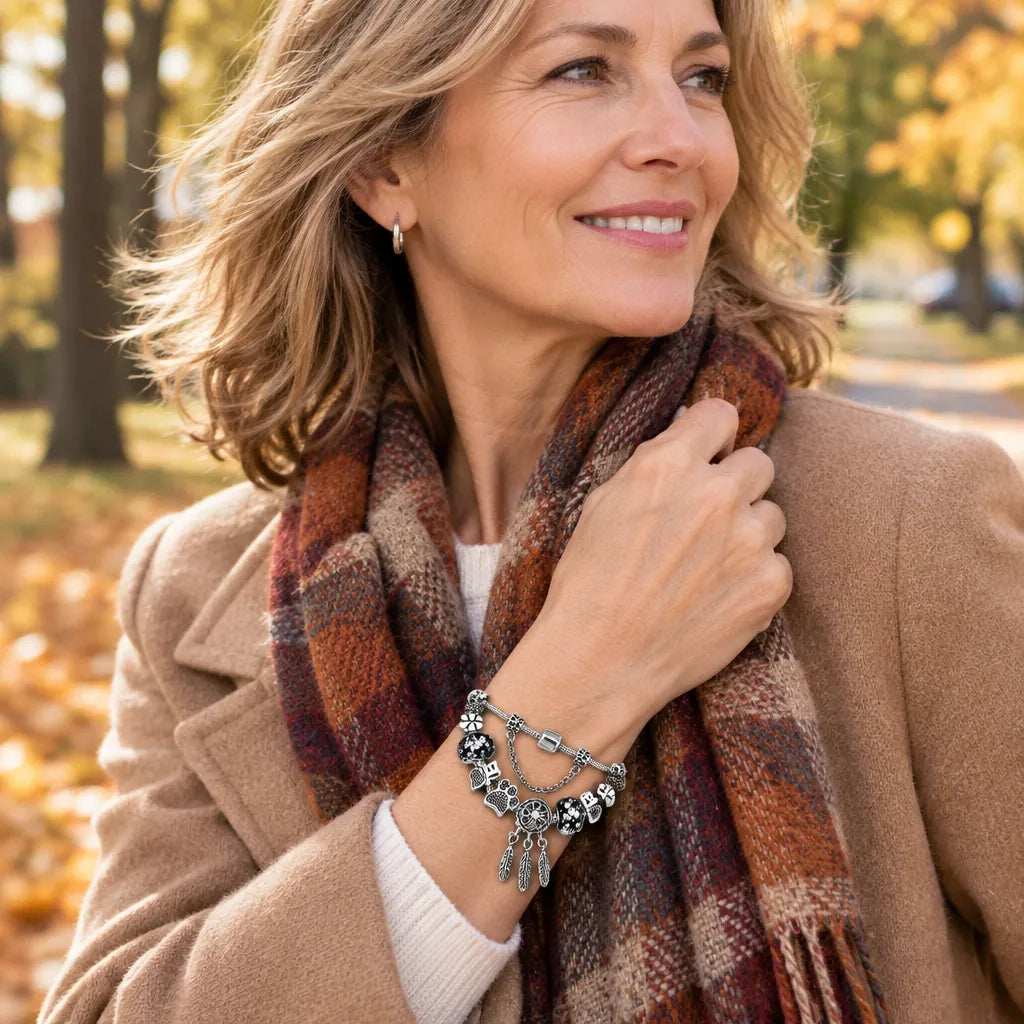 Woman in an autumn park wearing a silver charm bracelet with paw print charms