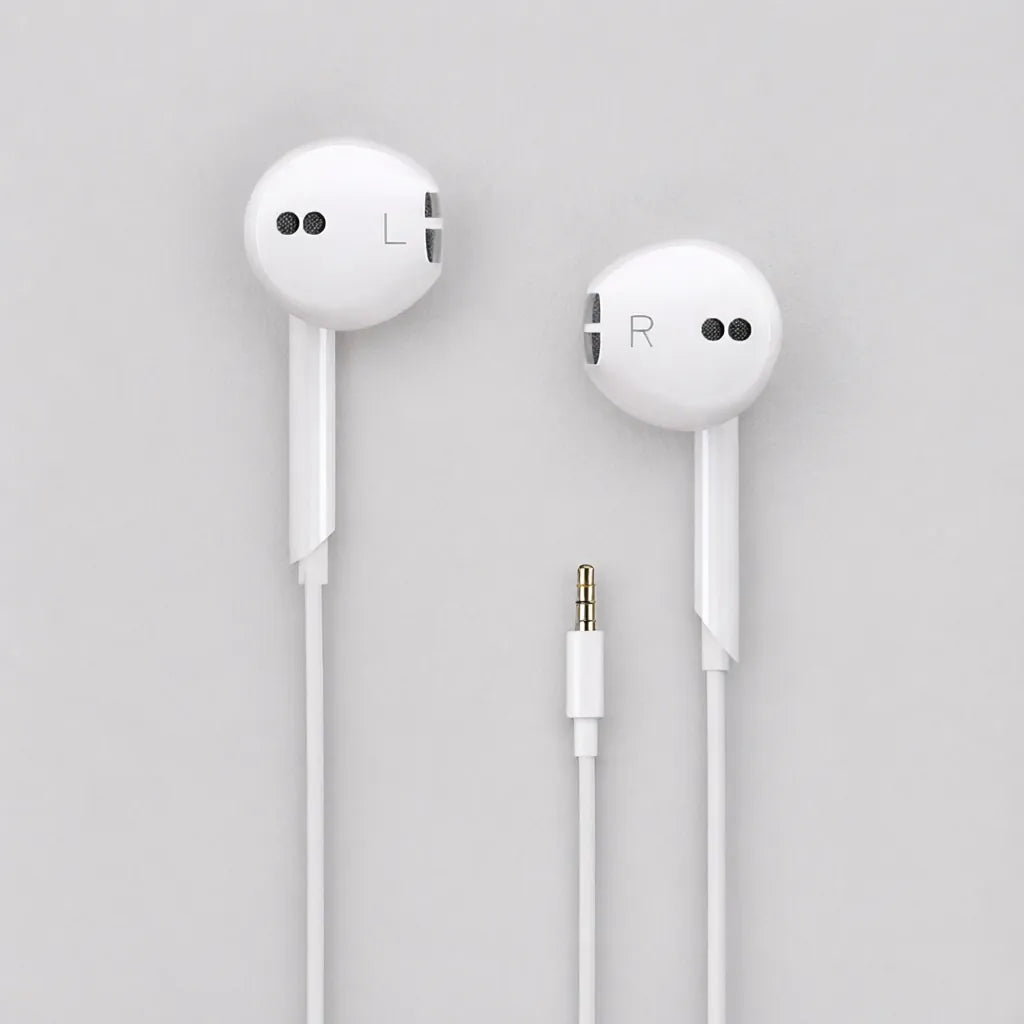 One pair of white wired earbuds with cable and plug laid flat on a grey surface