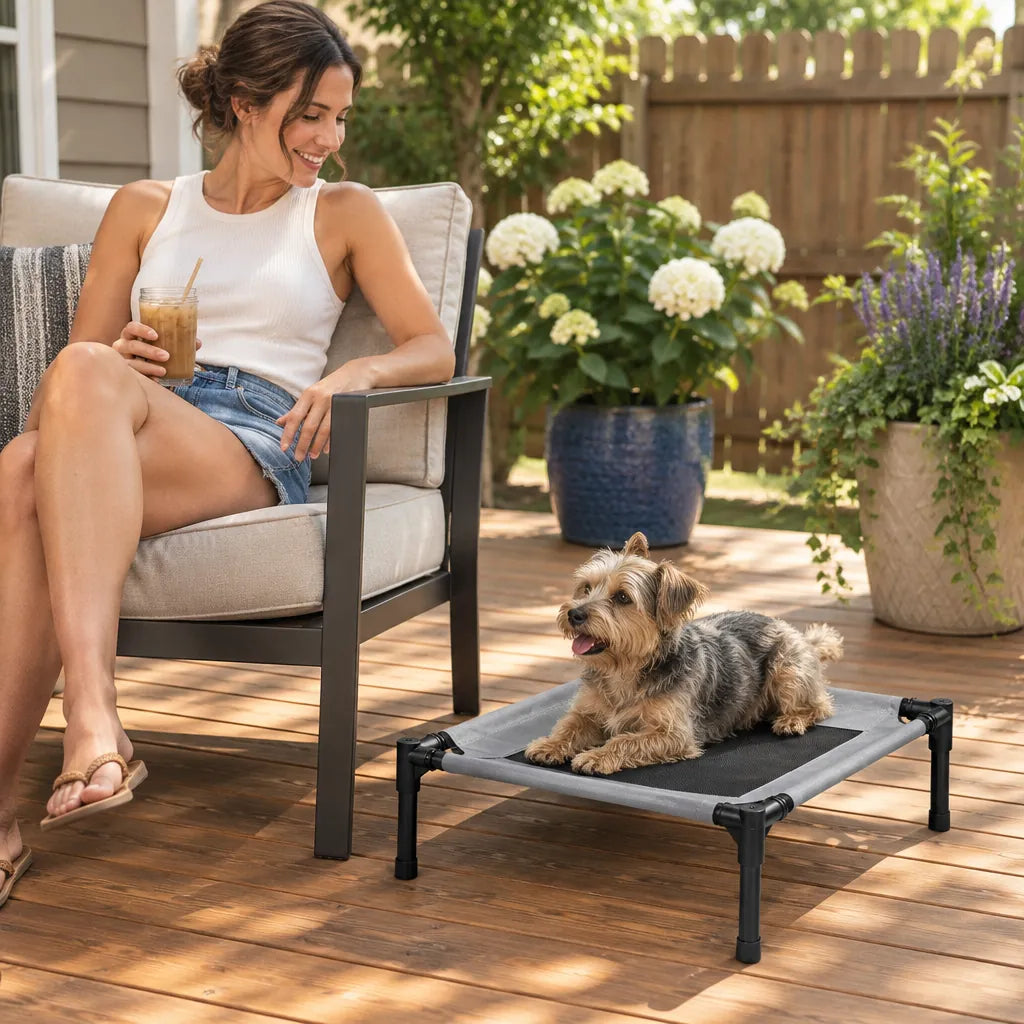 Woman on a patio chair next to her terrier on an outdoor dog bed