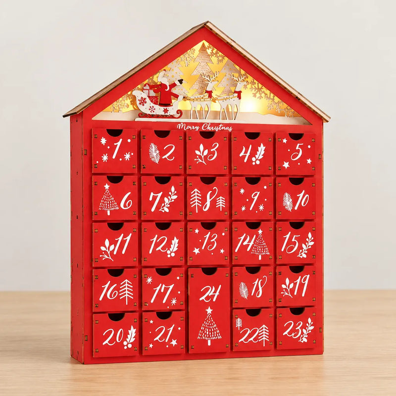 Casita de madera roja, calendario de adviento con 24 cajones sobre una mesa