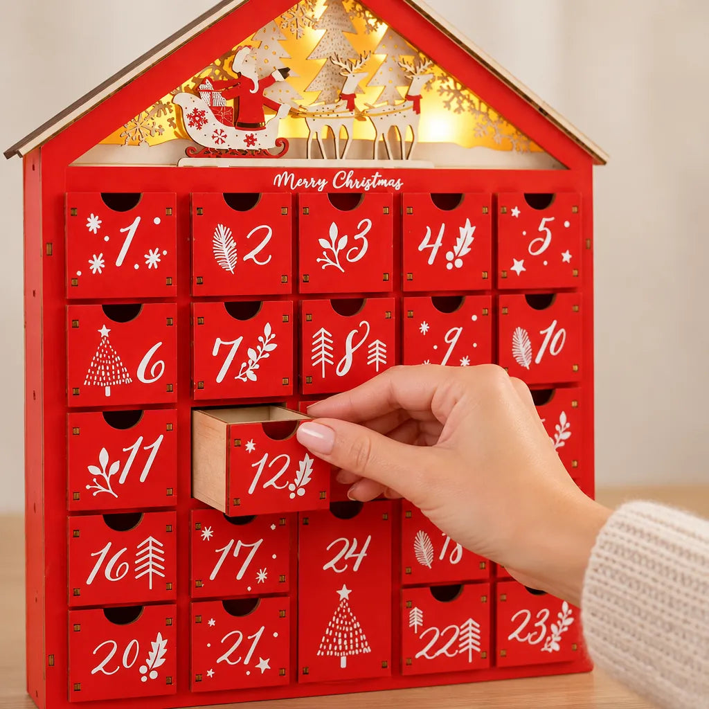 Hand opening drawer 12 of a red wooden advent calendar house with 24 drawers
