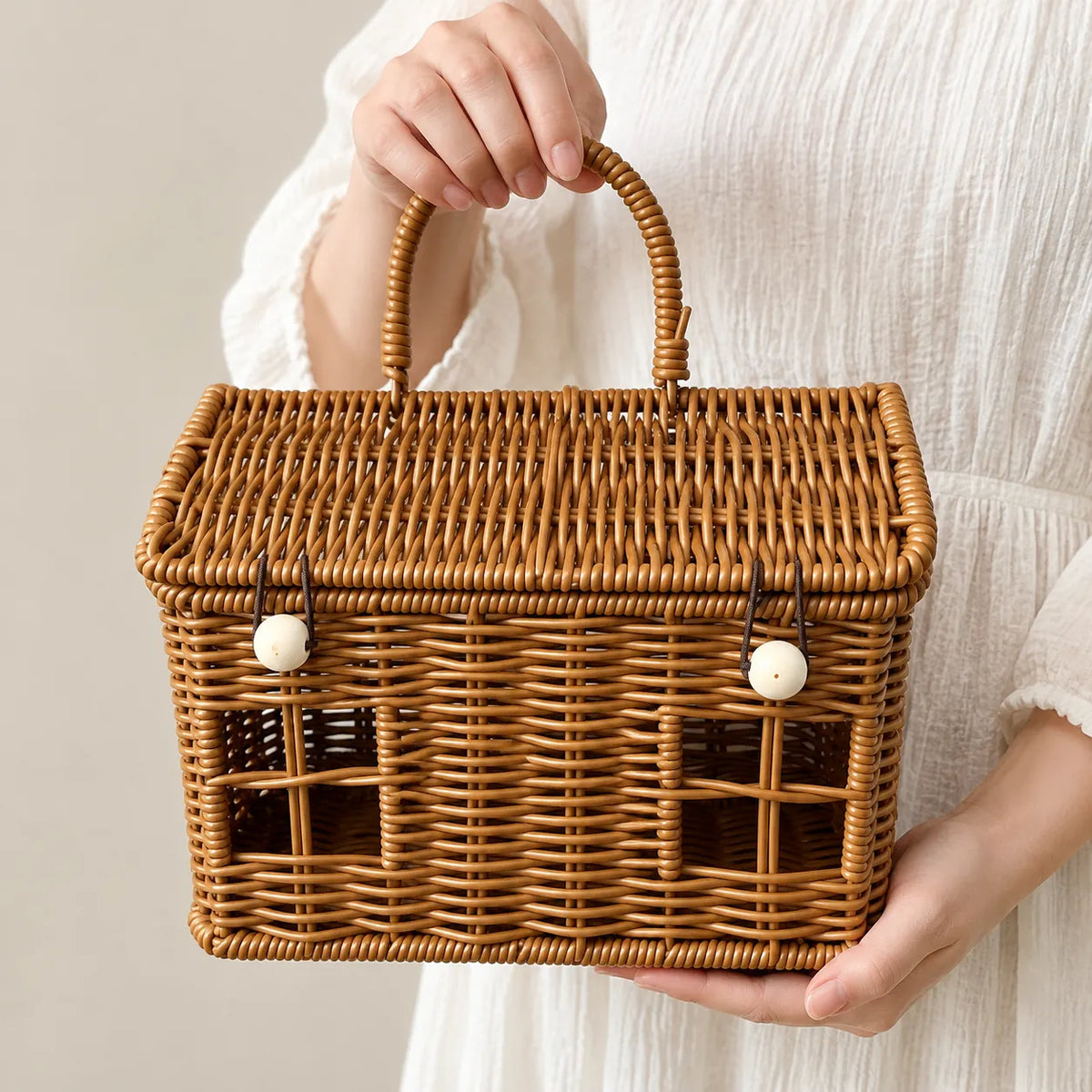 Hands holding a honey brown woven christmas hamper basket with lid by its handle