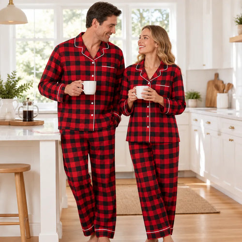 Couple in matching red plaid Christmas pajamas holding coffee in a kitchen