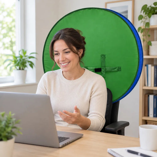 Woman smiling on a laptop call with a portable green screen behind her chair