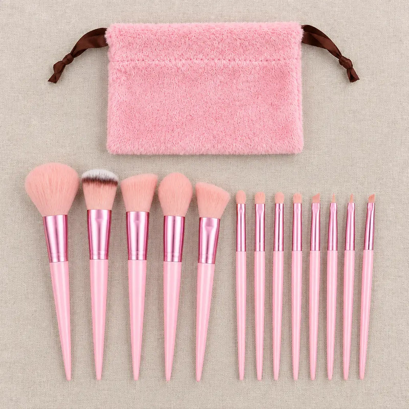 13 rosa Make-up Pinsel in einer Reihe mit rosa Kordelbeutel auf Leinen