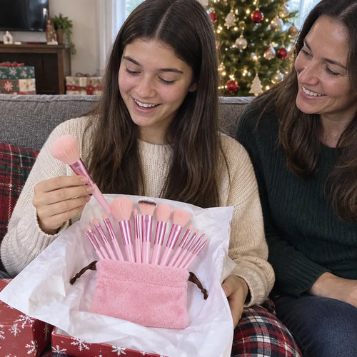 Teenagerin packt zu Weihnachten ein rosa Make-up Pinsel Set im Beutel aus, die Mutter lächelt