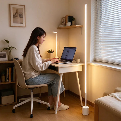 Estudiante con laptop junto a una lámpara de pie LED blanca de esquina