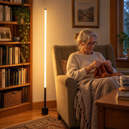 Dame âgée qui tricote dans un fauteuil près d'une lampe sur pied LED, coin lecture