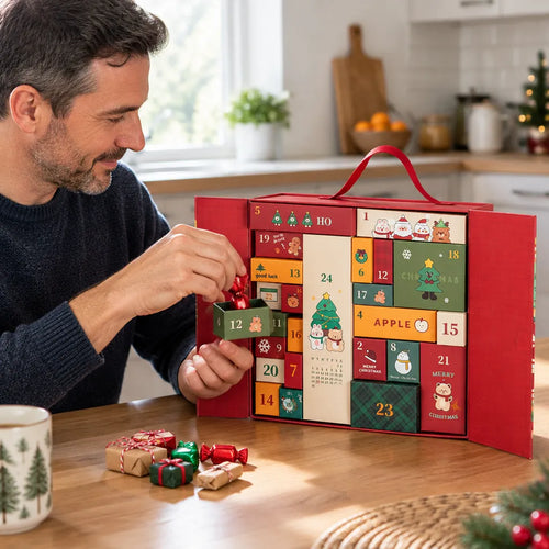 Mann befüllt am Küchentisch den Adventskalender mit kleinen Leckereien