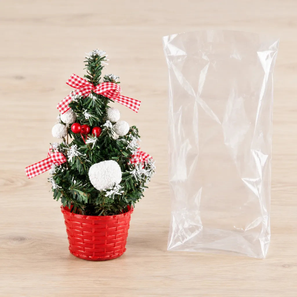 Mini Christmas tree in a red pot next to its clear plastic bag