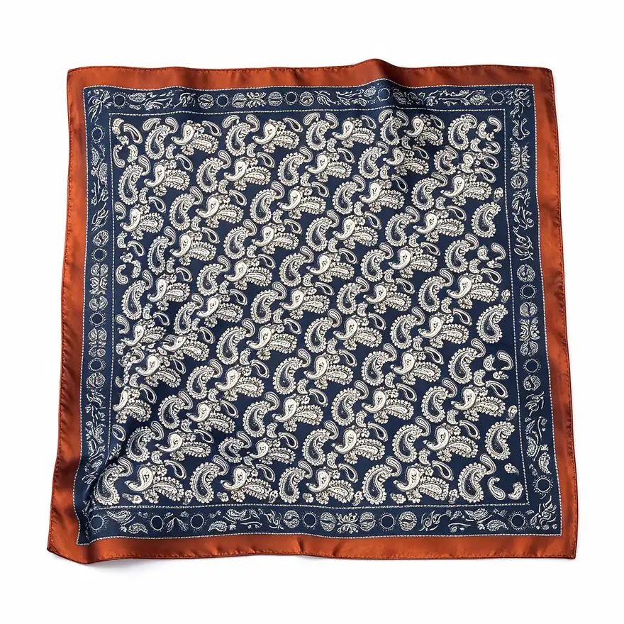 Navy paisley square scarf with a rust-orange border laid flat on white