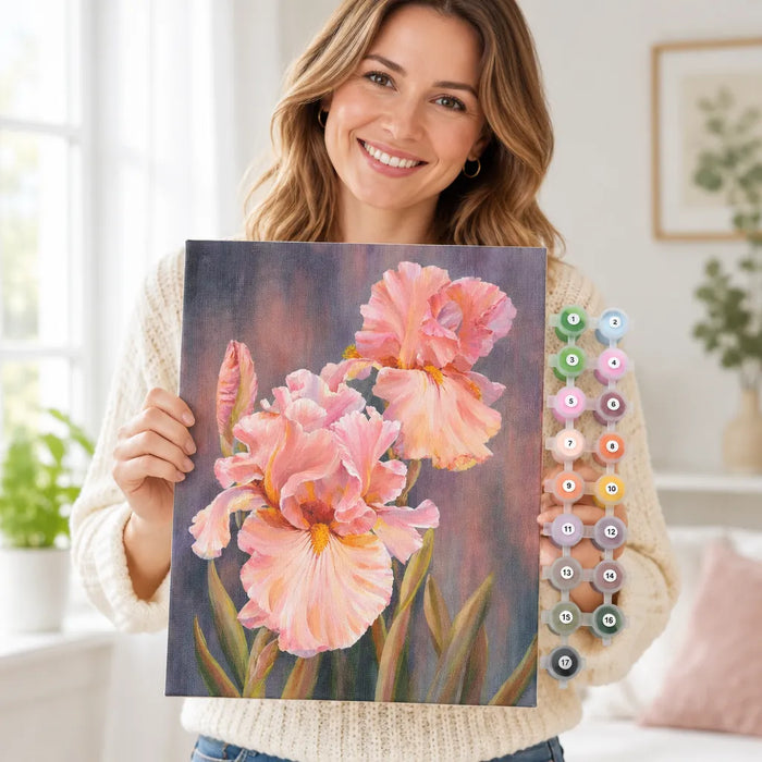 Lächelnde Frau hält ihr fertiges Iris-Bild aus dem Malen-nach-Zahlen-Set hoch