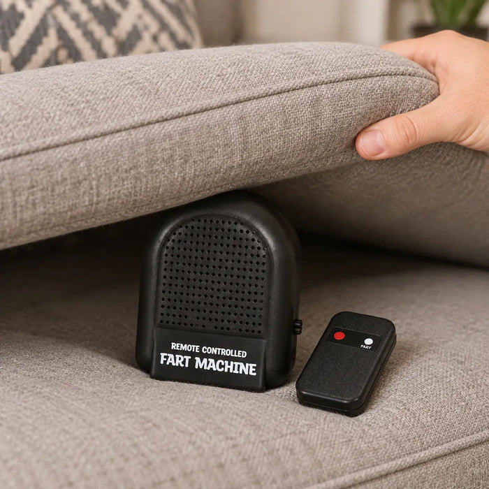 Mano escondiendo la bocina negra debajo de un cojín del sillón junto a su control