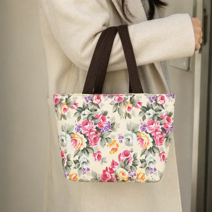 Woman sliding the brown handles of a mini tote bag over her forearm