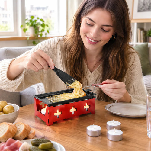 Frau schabt am Couchtisch geschmolzenen Käse aus dem Mini-Raclette-Set auf Brot