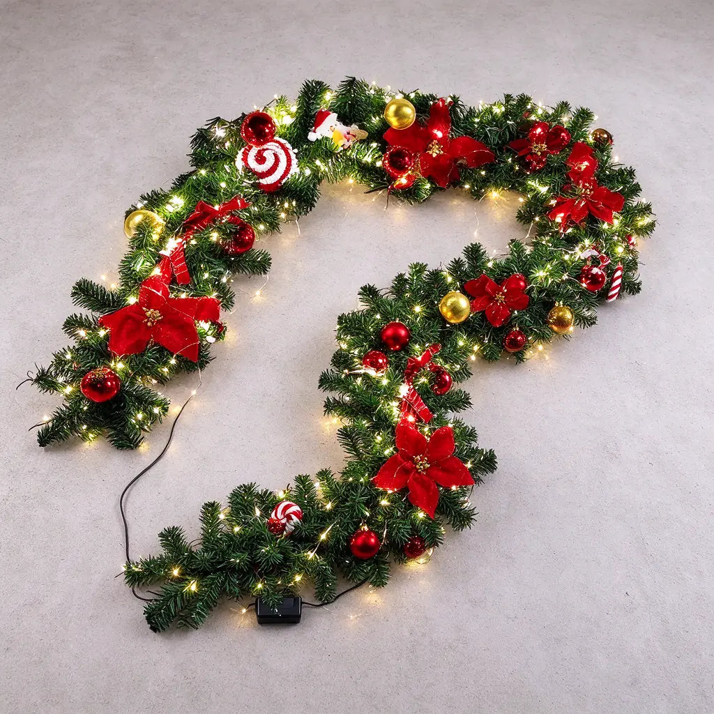 One pre-lit christmas garland with a battery pack laid out on a grey floor