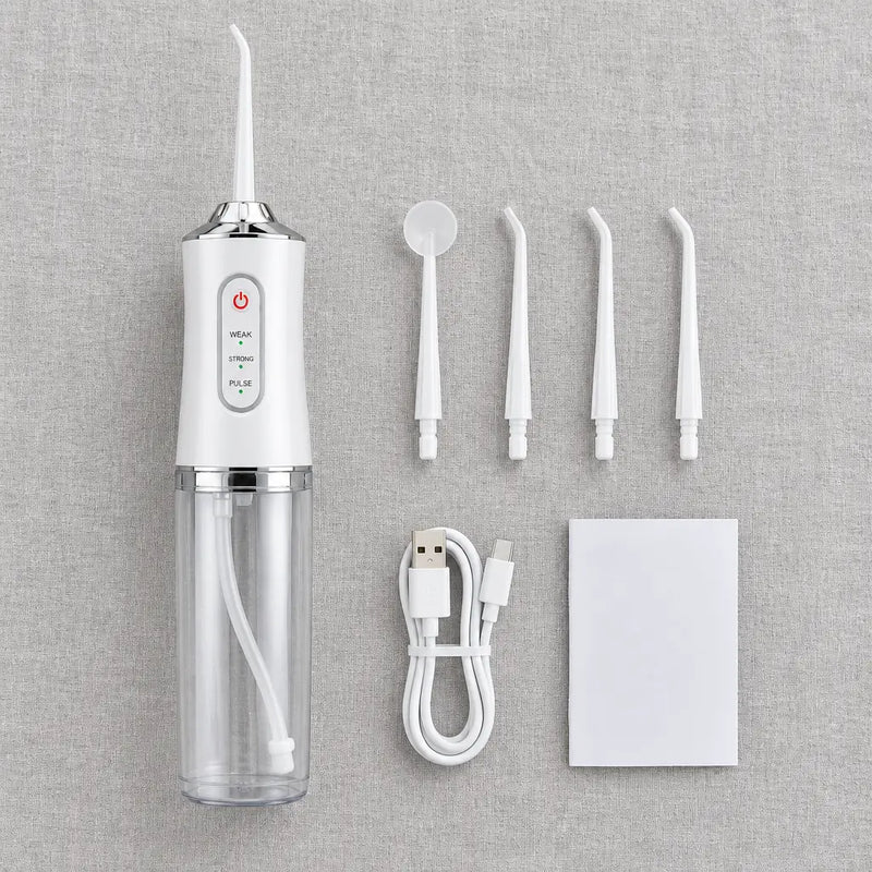 Cordless water flosser laid out with four tips, a USB charging cable and a manual