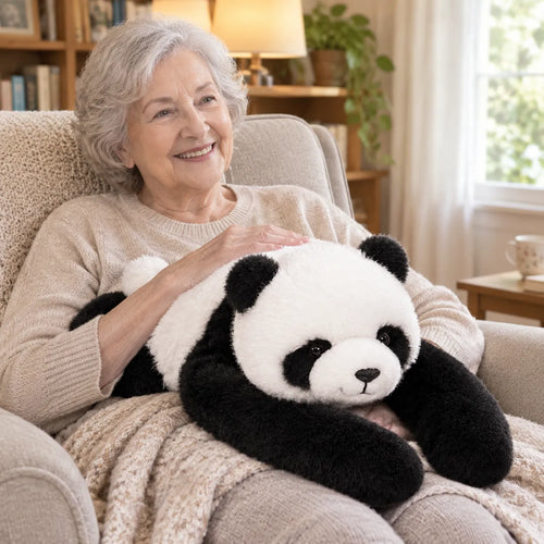 Ältere Frau lächelt im Sessel mit einem Gewichtskuscheltier Panda