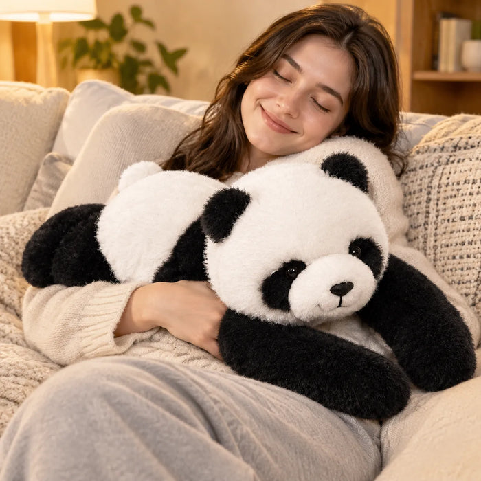 Lächelnde Frau kuschelt auf dem Sofa mit einem Gewichtskuscheltier Panda