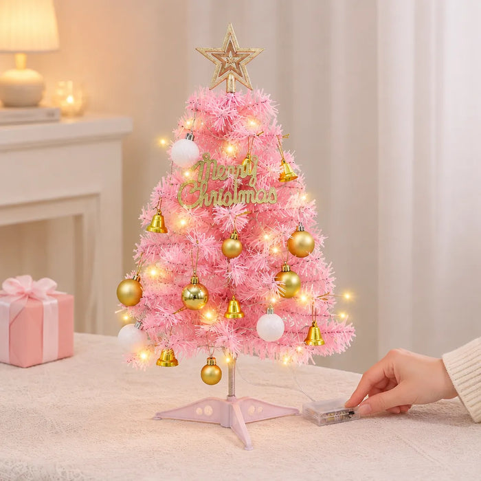 Hand switching on the battery box of a pink Christmas tree with LED lights