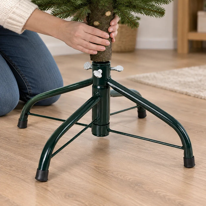 Manos metiendo el tronco de un arbolito en una base metálica para árbol de Navidad