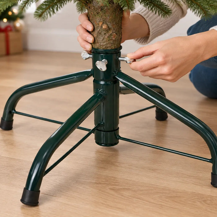 Manos apretando el tornillo de mariposa de una base metálica para árbol de Navidad