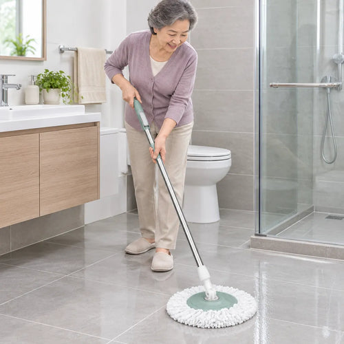Señora mayor trapeando el piso de mosaico del baño con un trapeador giratorio