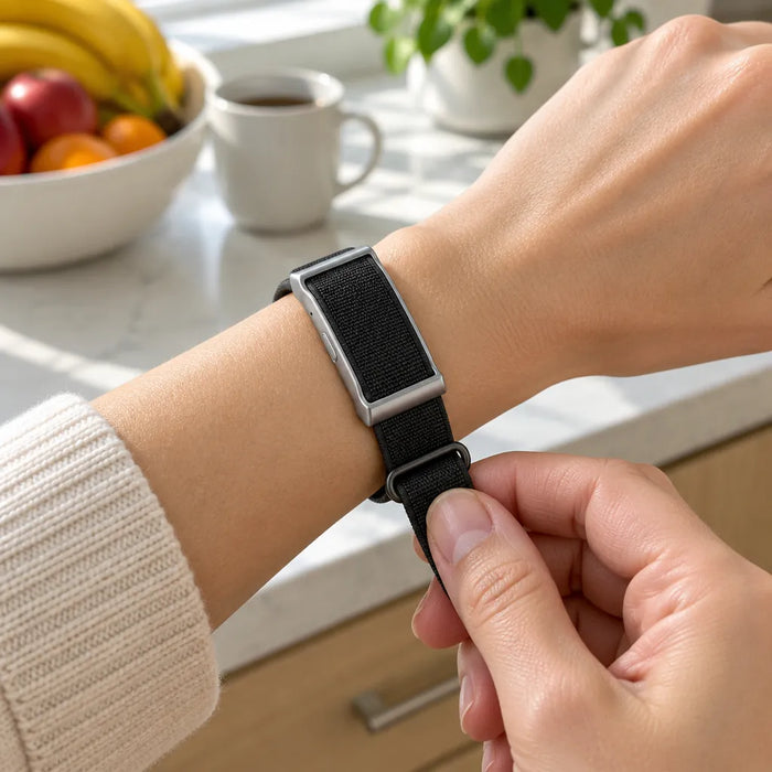 Hands tightening the woven strap of a fitness band through its D-ring