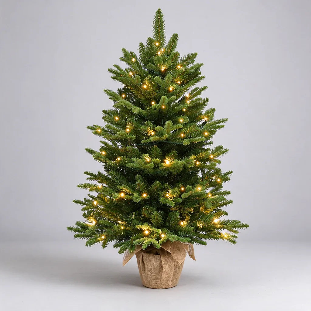One small artificial Christmas tree with lights in a burlap pot, shown on a plain grey surface