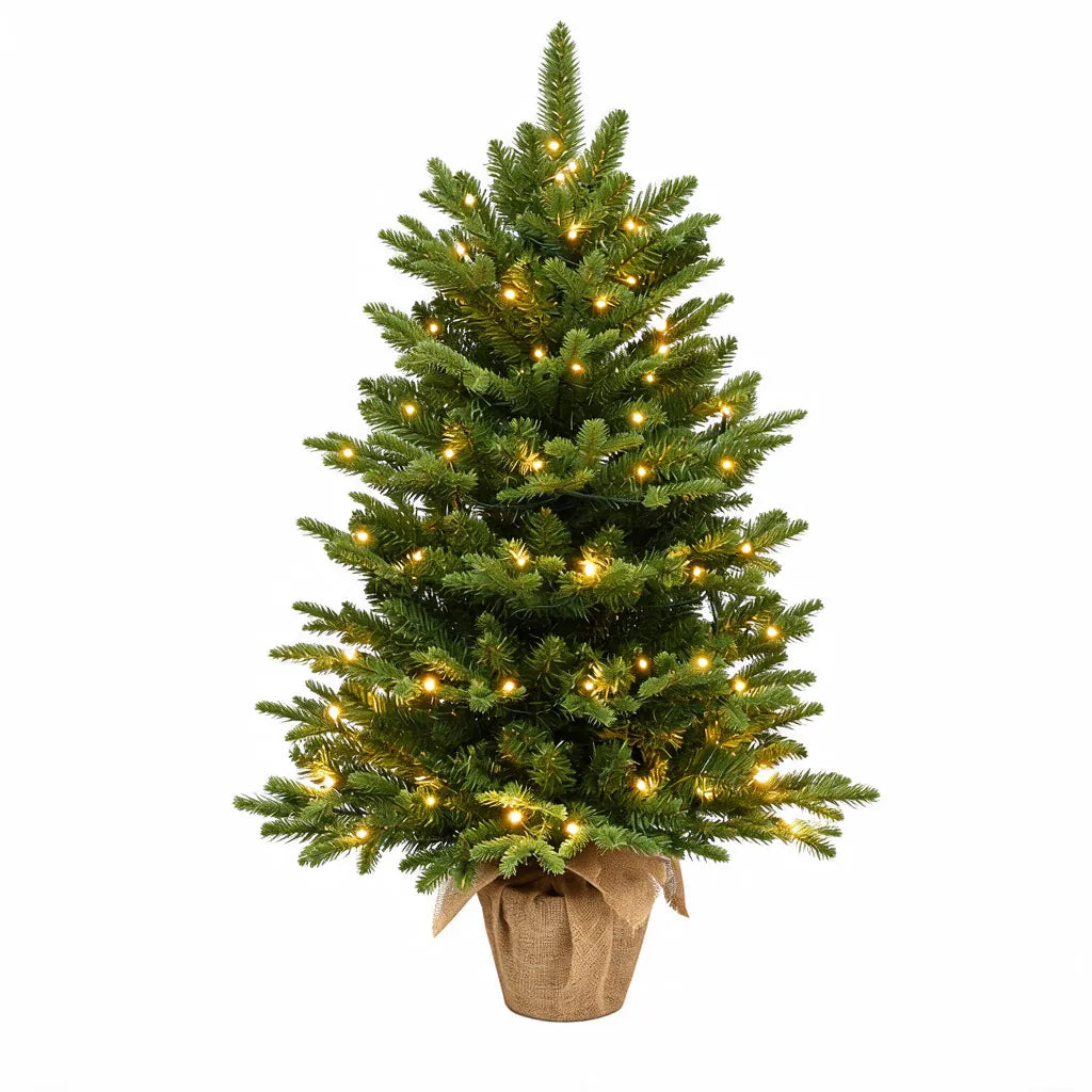 Small artificial Christmas tree with warm white lights in a burlap pot on a white background