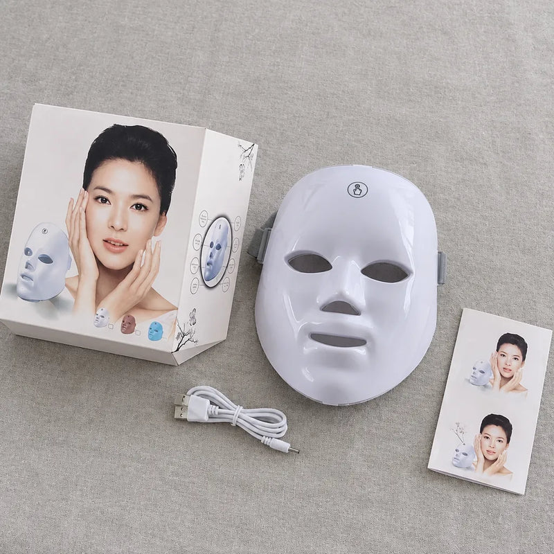 LED Gesichtsmaske mit USB-Kabel, Anleitungskarte und Originalverpackung auf Leinen