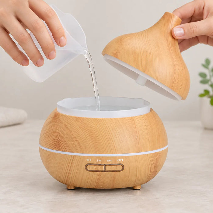 Pouring water into an essential oil diffuser with the cover lifted off