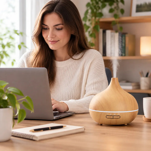 Woman working at a laptop with an essential oil diffuser on her desk