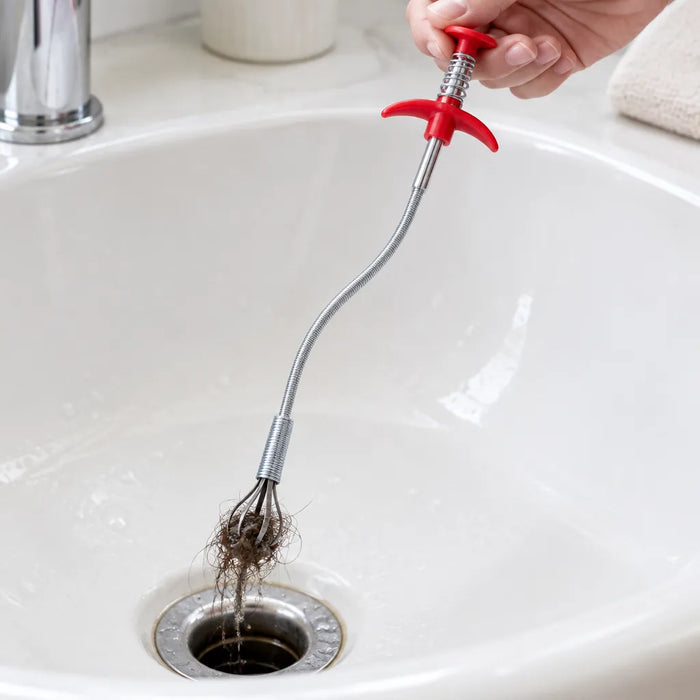 Drain snake claws pulling a hair clog out of a sink drain
