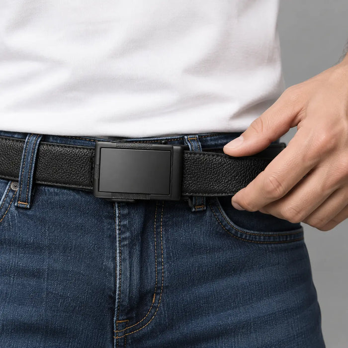 Hand adjusting a black ratchet belt at the waist of blue jeans