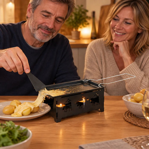 Zwei Freunde streifen geschmolzenen Käse vom Teelicht-Raclette-Set auf Kartoffeln am Küchentisch