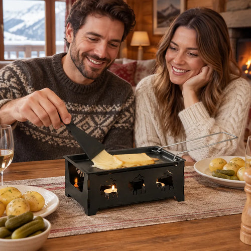 Paar schmilzt Raclettekäse mit einem Mini Raclette Ofen am Esstisch neben Pellkartoffeln