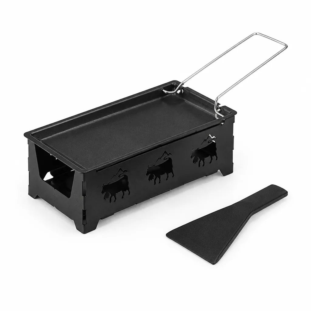 Black mini raclette set with cut-out hob, non-stick cheese pan and spatula on a white background