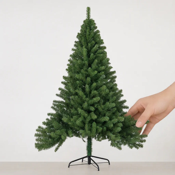 Hand lowering a branch tier of a green artificial Christmas tree so it opens out from the trunk